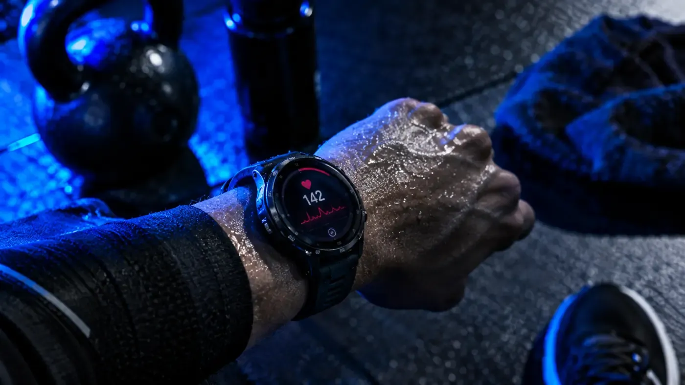 Montre connectée de sport affichant les données d'entraînement au poignet, ambiance studio bleu profond, mur noir, scène sportive premium